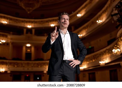 Motivational Speaker In Formal Elegant Suit, Talking About Happiness, Self, Success And How Better More Productive Self. Tech Startup Presenter Pitching. Handsome Caucasian Male On Stage