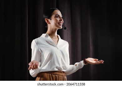 Motivational speaker with headset performing on stage - Shutterstock ID 2064711338