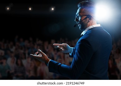 Motivational speaker with headset performing on stage - Powered by Shutterstock