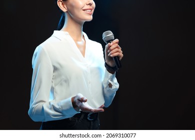 Motivational Speaker With Microphone Performing On Stage, Closeup. Space For Text