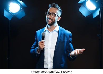 Motivational speaker with microphone performing on stage - Powered by Shutterstock