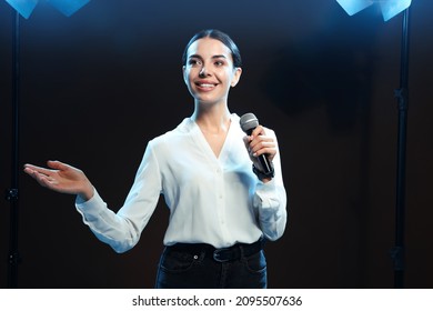 Motivational speaker with microphone performing on stage - Powered by Shutterstock