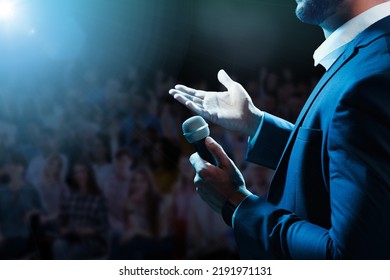 Motivational speaker with microphone performing on stage, closeup - Powered by Shutterstock