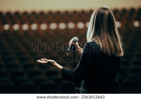 
Motivational Speaker Rehearsing Presentation in Empty Theater Room. Spokesperson practicing alone before giving a public presentation
