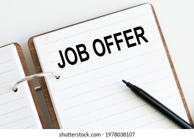 Motivational Words: JOB OFFER On The Notebook Next To A Black Marker. Business And Finance Concept