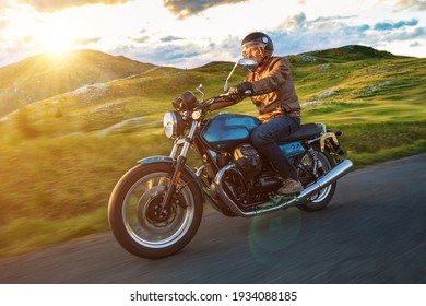 Moto racer riding on forest road during sunset, blurred motion.
