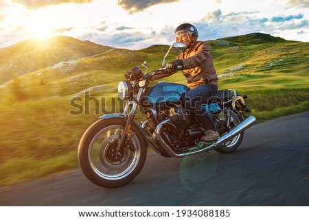 Moto racer riding on forest road during sunset, blurred motion.