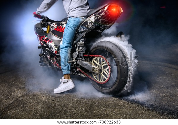 Moto rider making a stunt on his\
motorbike. Biker doing a difficult and dangerous\
stunt.