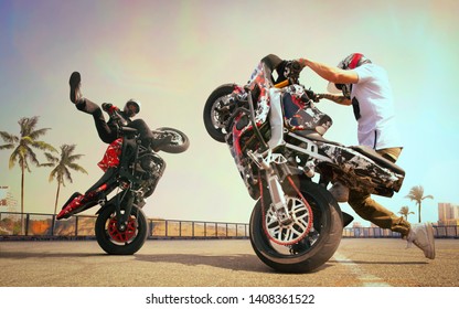 Moto Riders Making A Stunt On His Motorbike. Biker Doing A Difficult And Dangerous Stunt.