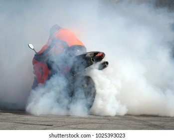 Moto show. Biker on a motorcycle drifts in clouds of smoke