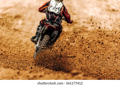 Motocross, Enduro Rider Accelerating In Dirt Track With Debris Flying Away