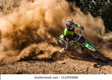 Motocross rider creates a huge cloud of dust and debris - Shutterstock ID 1112943086