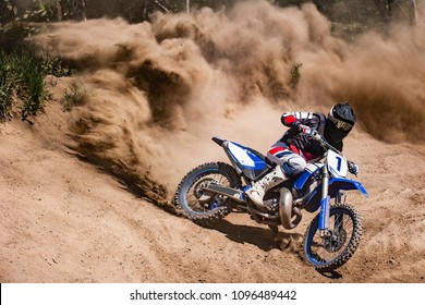 Motocross rider creates a large cloud of dust and debris