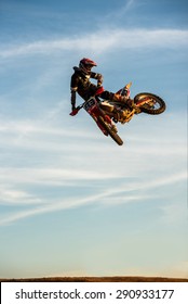 Motocross Rider Jump In A Blue Sky With Clouds