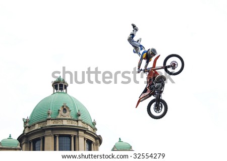 Motocross rider performing dangerous jumps with his bike isolated on white.