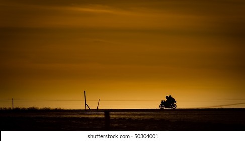 Motor Bike In On A Road In The Sunset