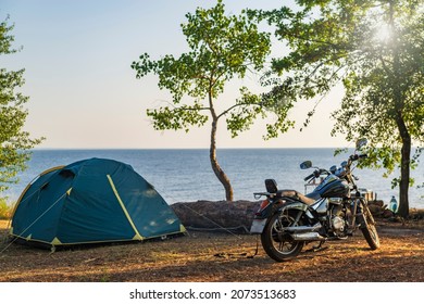 Motor bike and tent at the sea coast. Concept of summer travel and self isolation