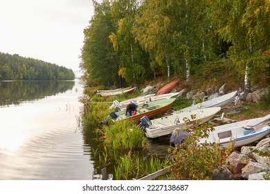 Motor boats, cutters and small fishing boats standing on land near the evergreen forest. Suiro lake (Kulovesi), Finland. Nature, ecotourism, hiking concepts - Powered by Shutterstock