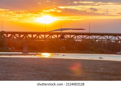 A Motor Glider At Sunset Over The Bridge