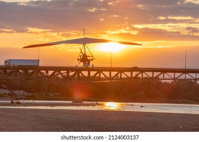 A Motor Glider At Sunset Over The Bridge