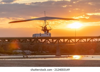 A Motor Glider At Sunset Over The Bridge