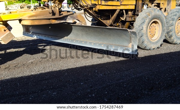 Motor grader car\
on asphalt road\
construction.