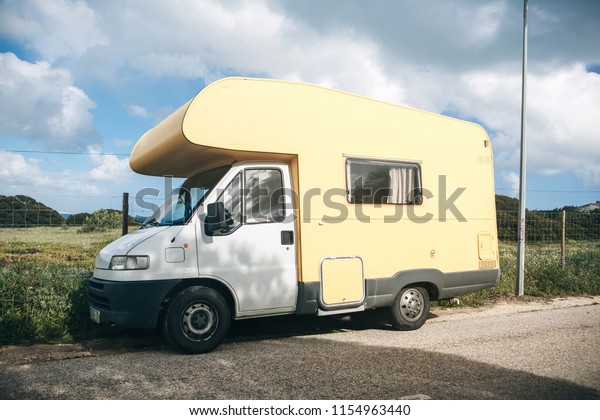 A motor home or a house on wheels is\
parked on the side of the road. Road trip or traveling by car.\
People sleep inside to rest for further\
travel.