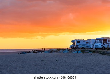 Motor homes, camper vans at sunset beach.Travel adventure vacation concept background.