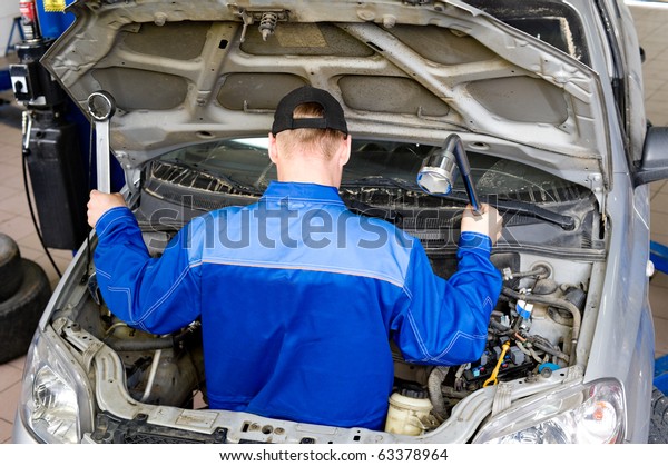 a motor mechanic\
repairs inside a car