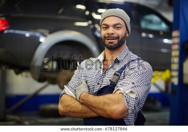 Motor\
mechanic with wrench in car service\
workshop