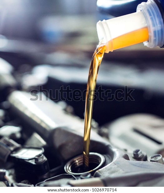 Motor oil pouring to car\
engine.
