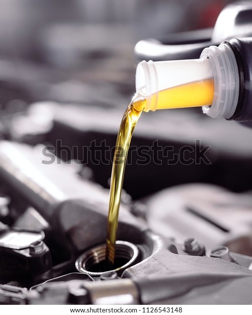 Motor oil pouring to car\
engine.