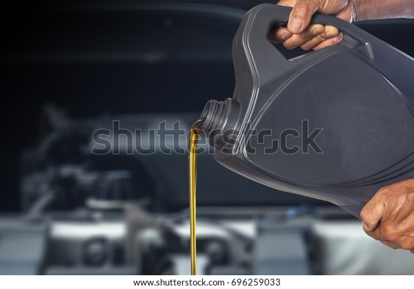 Motor oil pouring, Pouring oil lubricant motor car\
from bottle