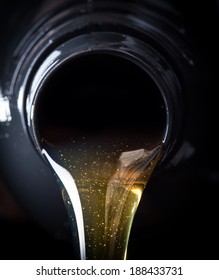 Motor oil pouring over black background