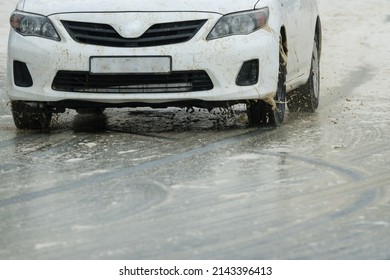 Motor Vehicle Or Car Driving On A Wet Tarred Or Asphalt Road Filled With Sea Foam After A Winter Storm With Selective Focus On The Right Tyres Concept Road Safety