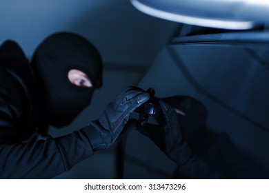 Motor Vehicle Theft Photo Concept. Car Theft In Black Gloves Stealing A Car.