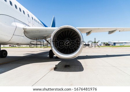 Motor and a wing of an aircraft plane at the airport. Airline, aeronautics, and travelling concept.