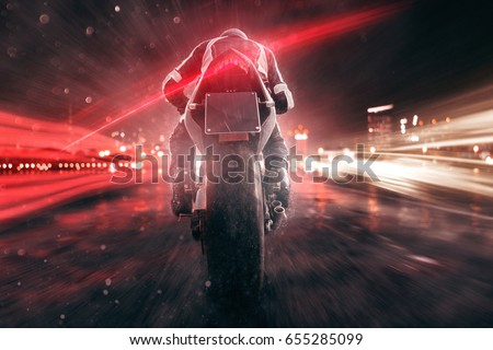 Motorbike drives through night city
