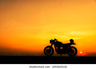 Motorbike Parking With Sunset Background. Biker Ride Motorcycle On Highway, Thailand. Silhouette Of Motobike And Helmet. Trip And Lifestyle Of Motorbike Concept.