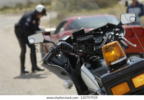Motorbike with police officer talking with\
driver in the\
background