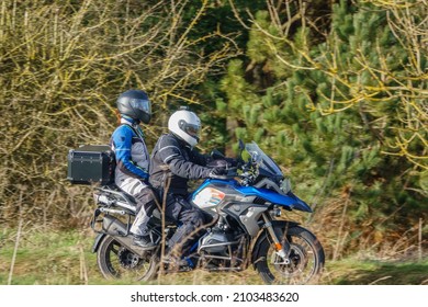 Motorbike Rider And Pillion Passenger On A BMW R1200 GS Motorcycle Travelling Through Winter Countryside