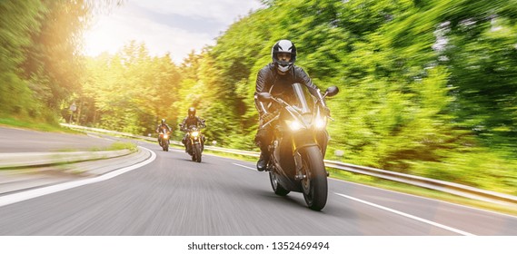 motorbiker on the forest road riding. having fun driving the empty road on a motorcycle tour journey. copyspace for your individual text. - Shutterstock ID 1352469494