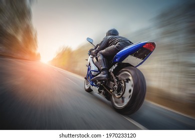 A motorbiker is rushing along the empty road at the high speed concept. Freedom. - Shutterstock ID 1970233120