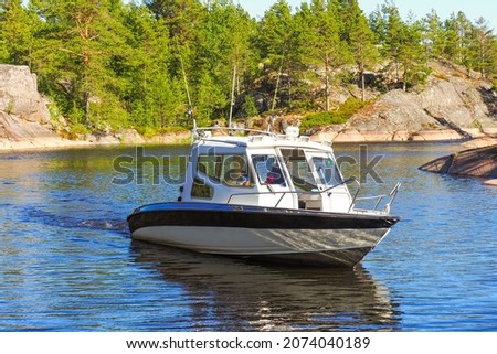 Motorboat floating on Ladoga Lake between islands. Ladoga skerries, northern nature. Travel to Karelia