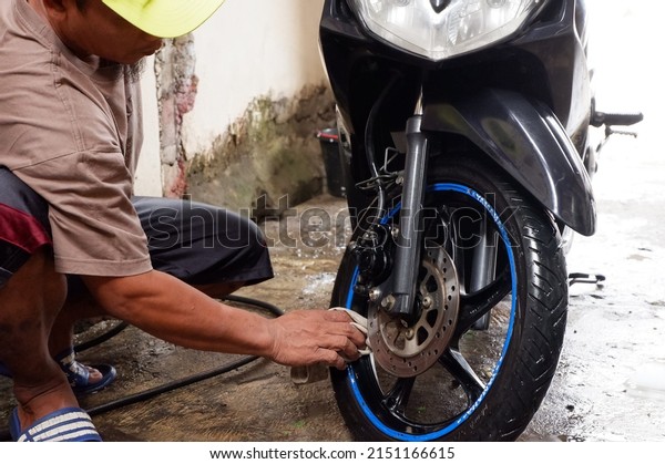 The motorcycle is being washed. Central Java,\
Indonesia, April 30, 2022