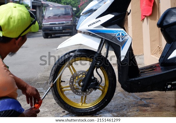 The motorcycle is being washed. Central Java,\
Indonesia, May 30, 2022