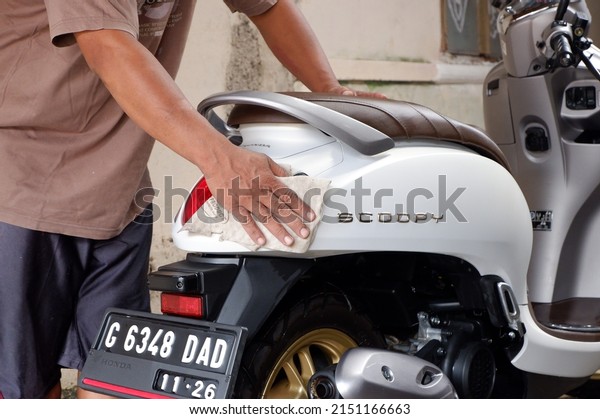 The motorcycle is being washed\
or sepeda motor merk honda jenis scoopy berwarna putih sedang\
dibersihkan dan dicuci. Central Java, Indonesia, April 30,\
2022