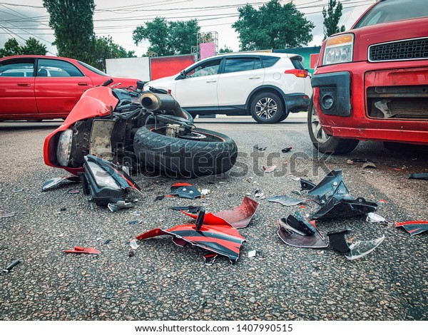 Motorcycle bike accident and car crash, broken and\
wrecked moto on road