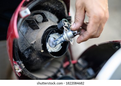 Motorcycle bulb replacement. holding a bulb with motorcycle. - Powered by Shutterstock