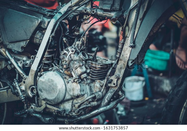 The motorcycle\
carburetor is waiting for maintenance and repair and the engine and\
mechanic check the engine.